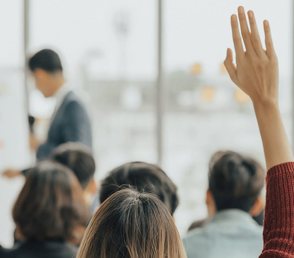 woman with a raised hand in class