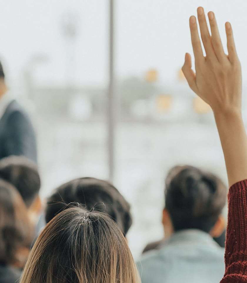 woman with raised hand in a class